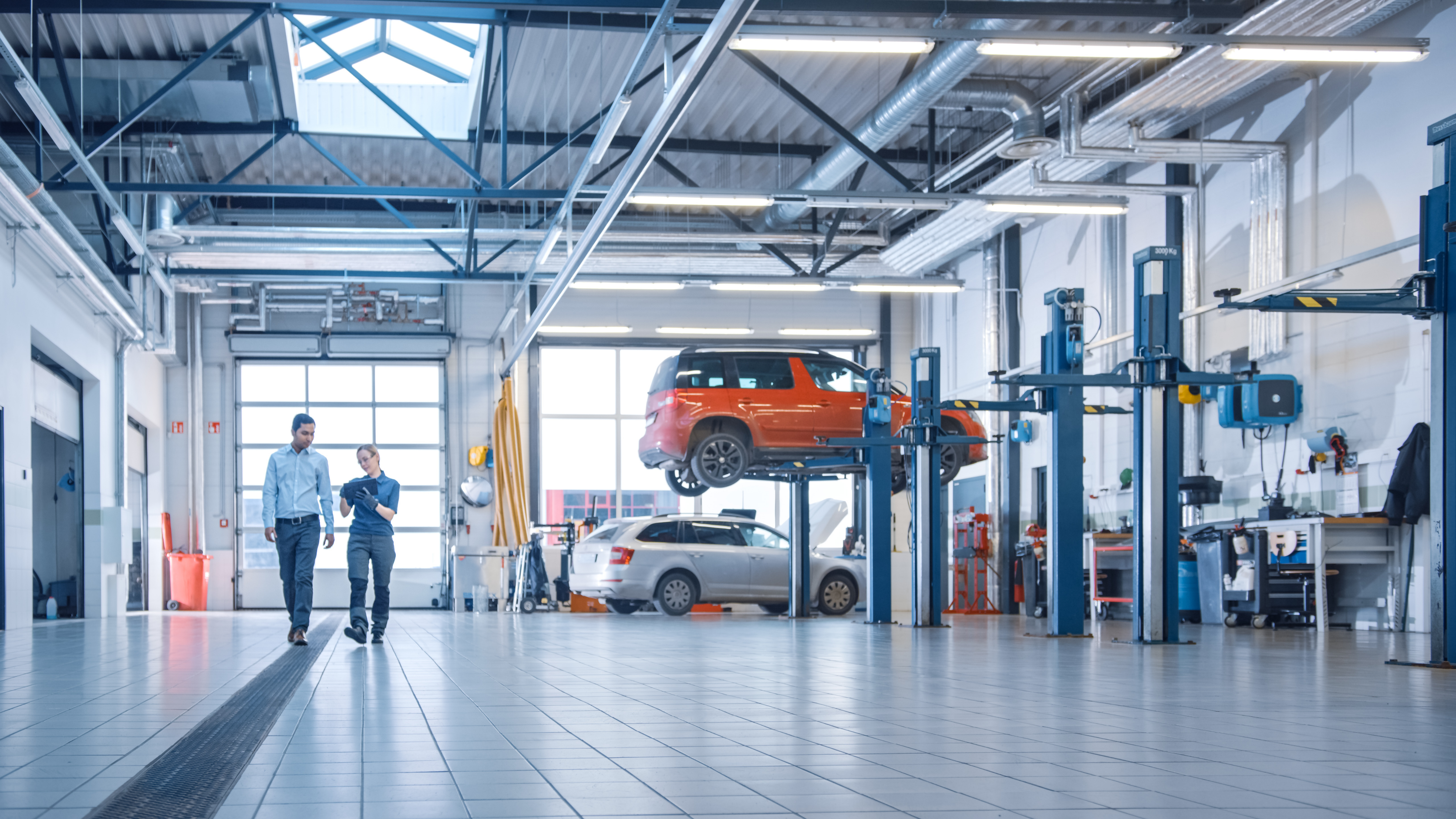 Mechanic and customer walking across garage