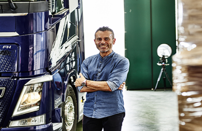 Mann neben dem Bus mit verschränkten Armen