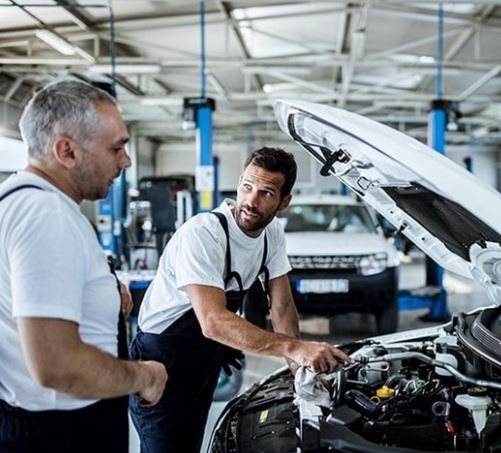 To mekanikere tjekker batteriet under motorhjelmen