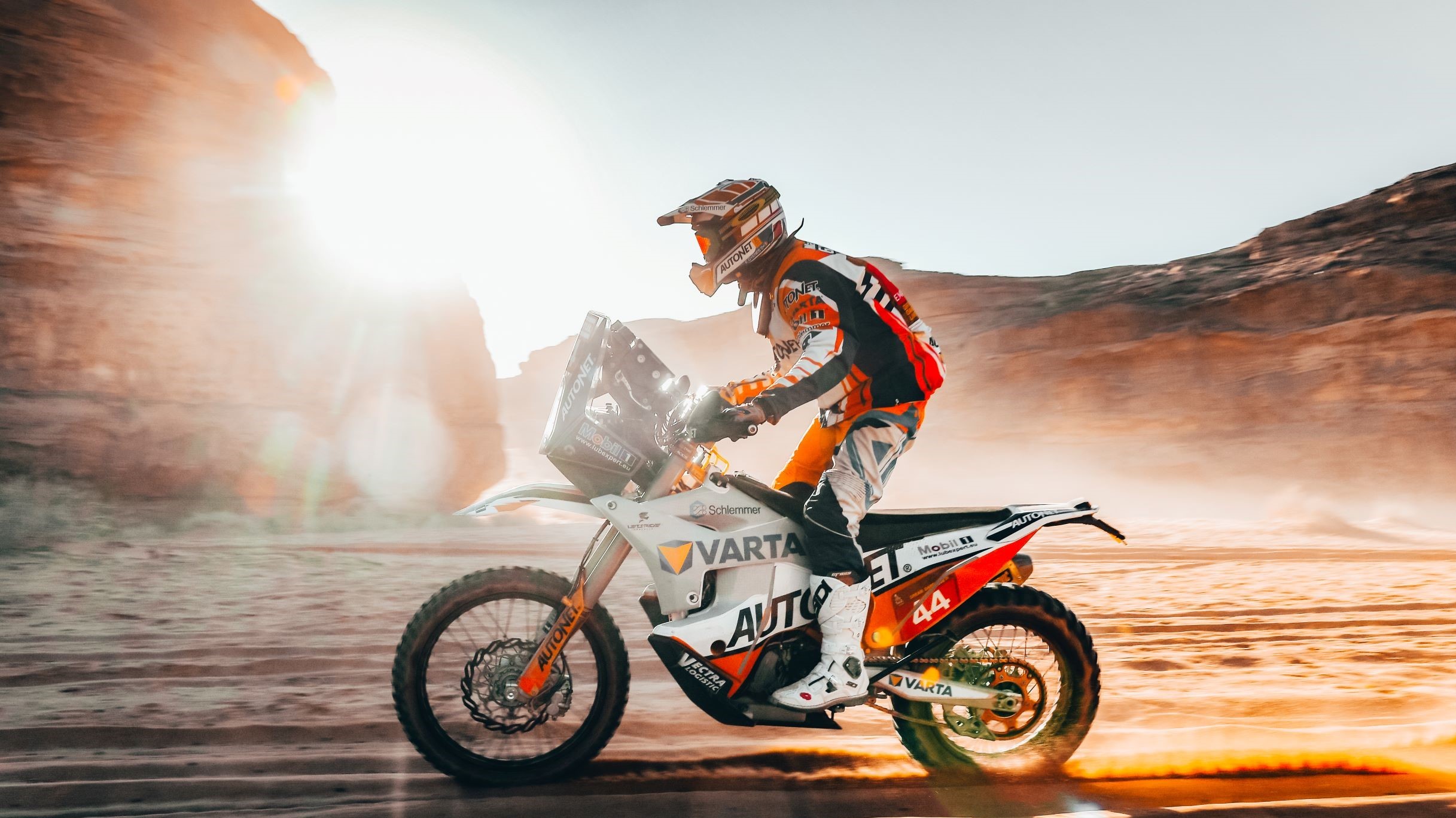 Mann fährt Motorrad entlang eines Canyons in der Wüste