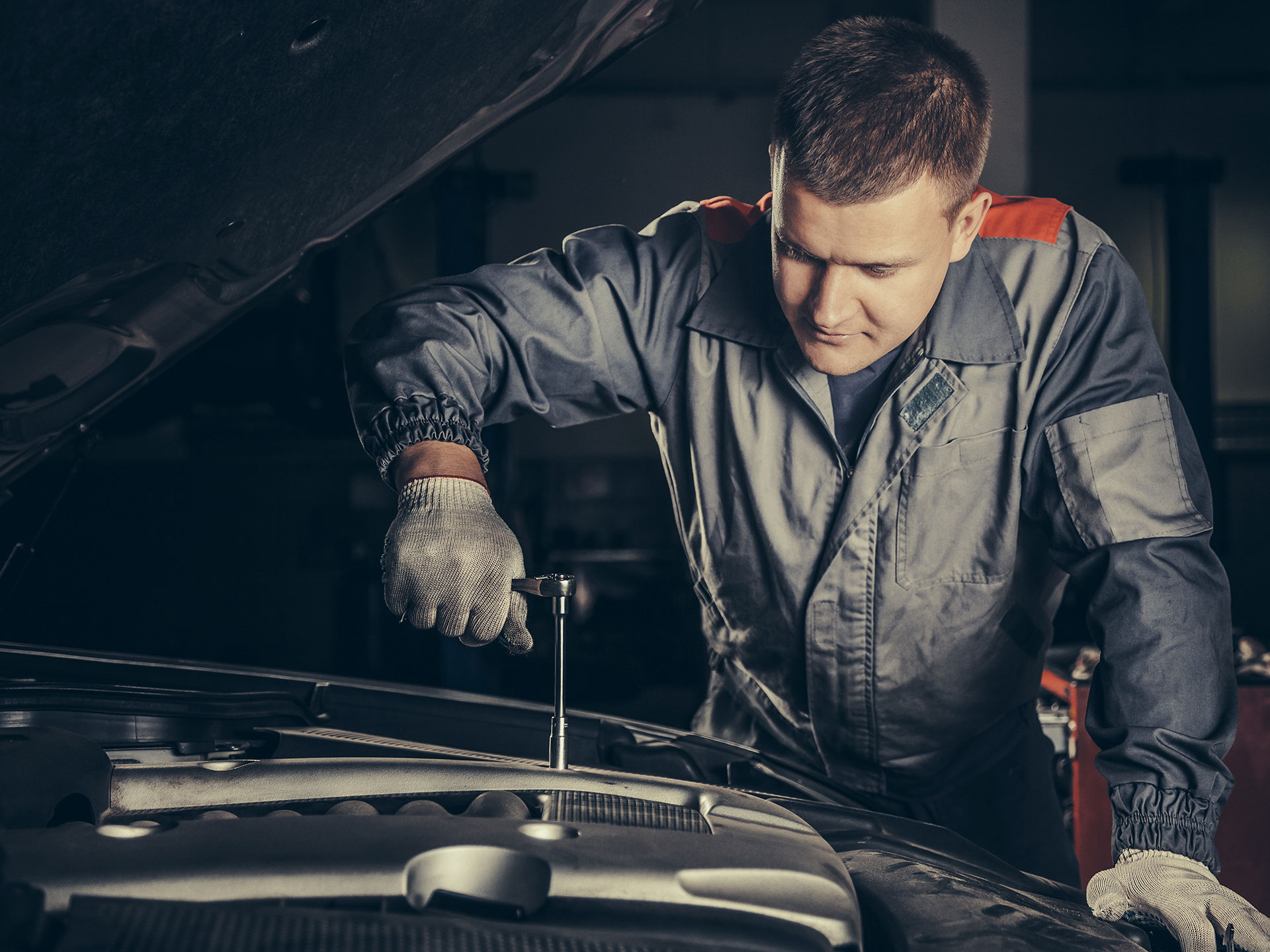 Mécanicien au travail sous le capot d'une voiture