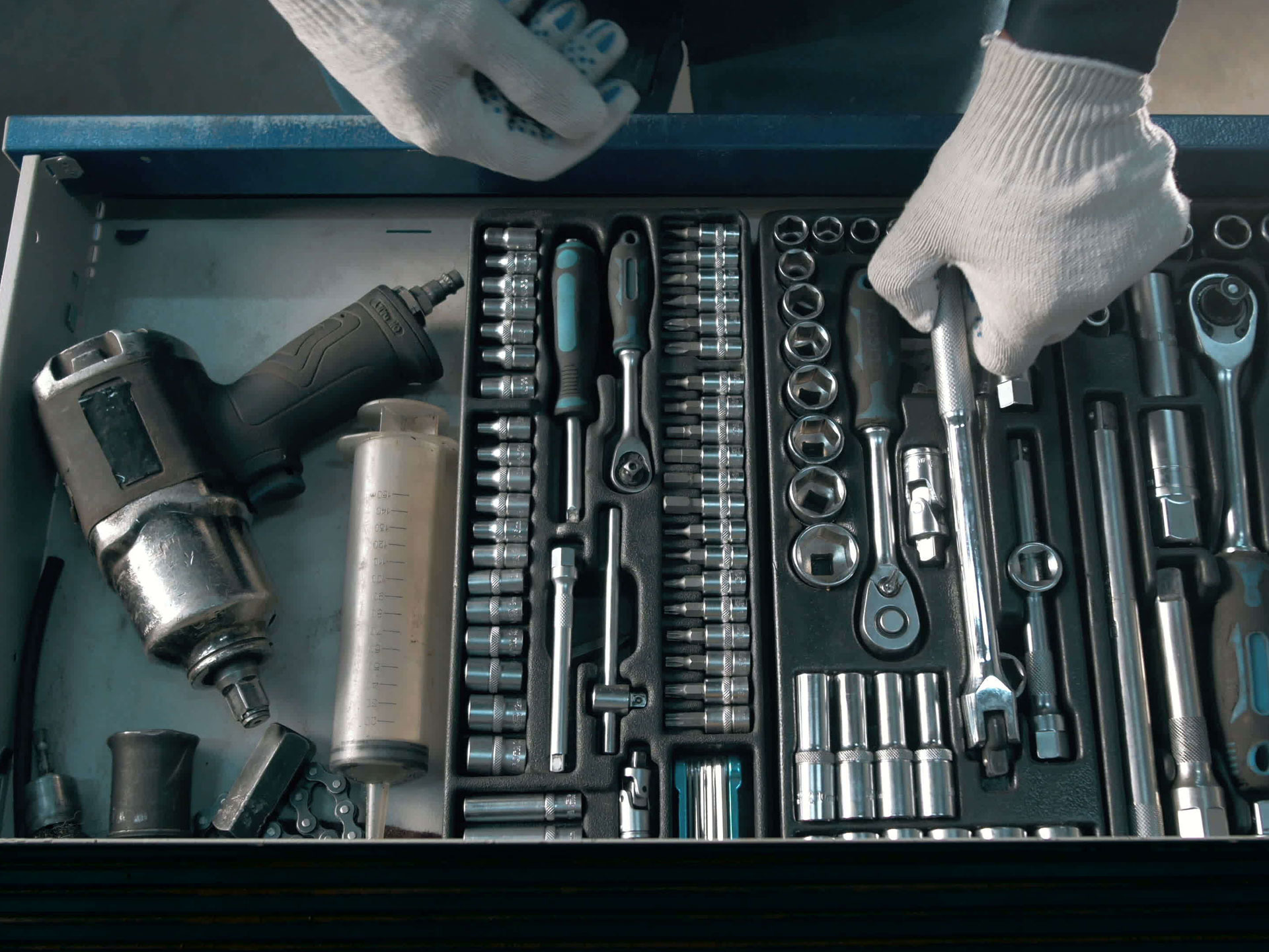 Mani che raccolgono un utensile nella cassetta degli attrezzi