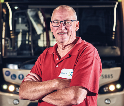 Mężczyzna przed autobusem ze skrzyżowanymi rękami